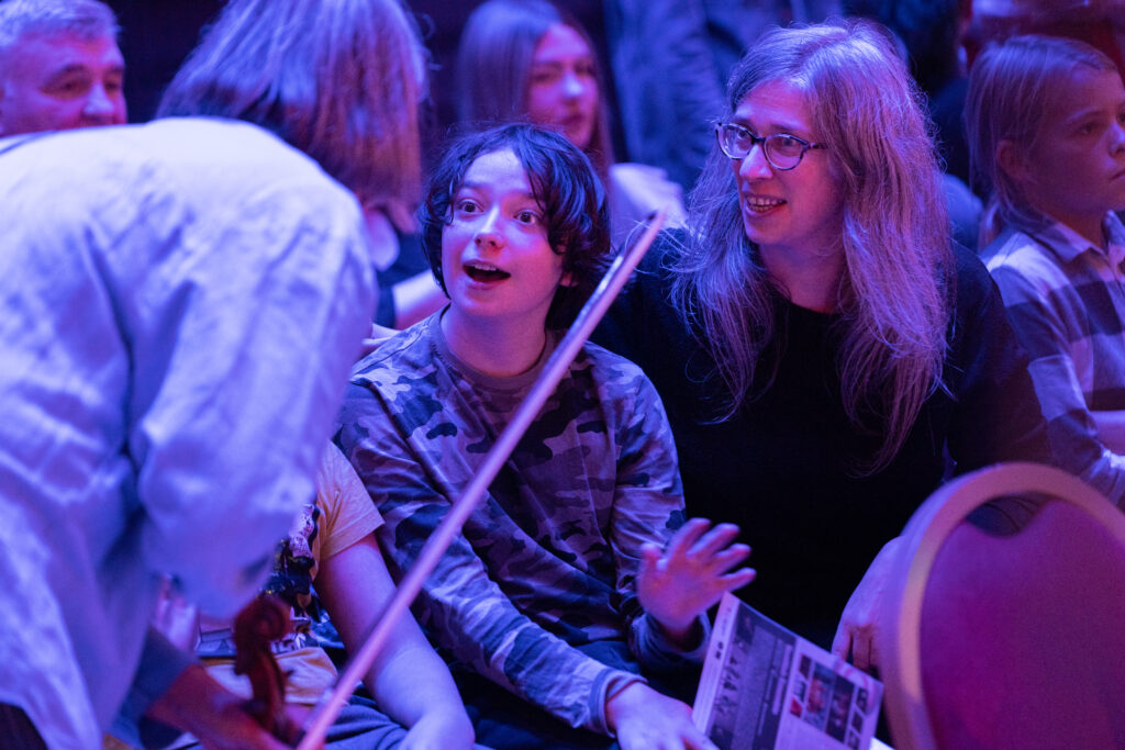String player talks to young audience member at in Sync.